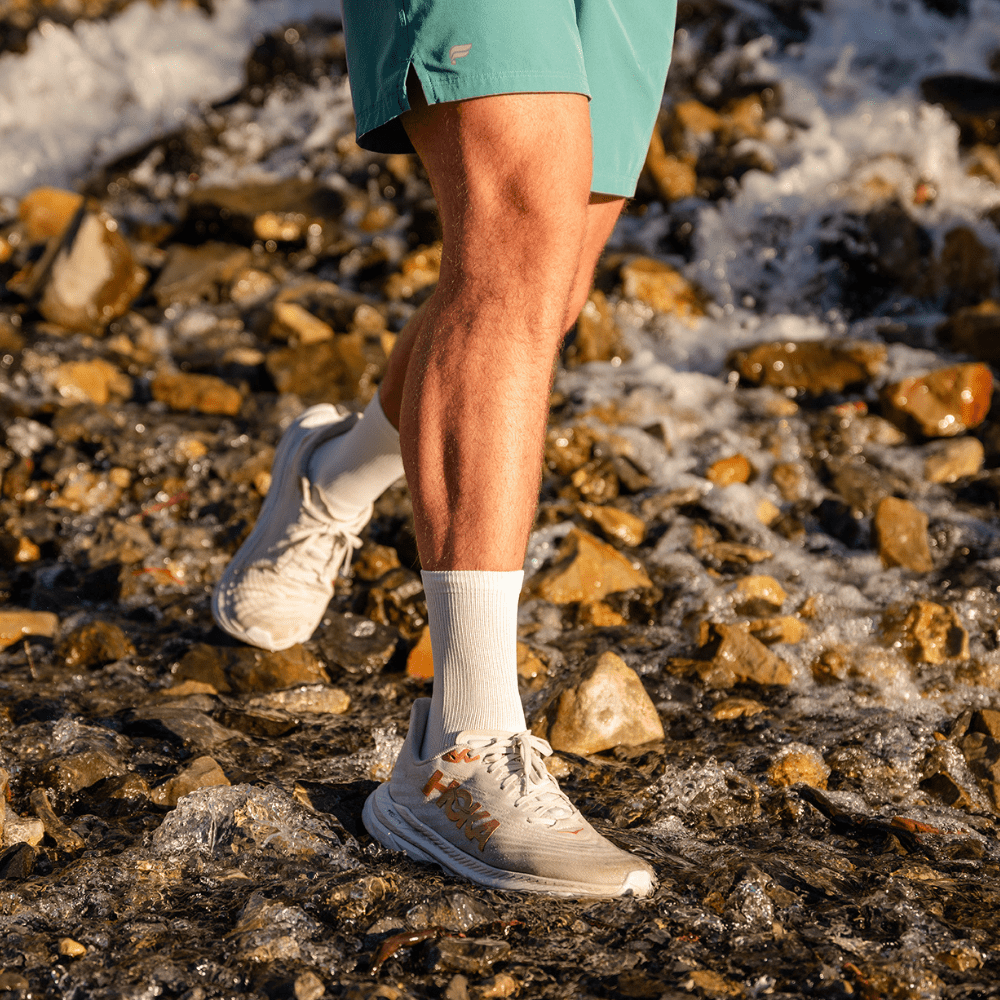 Man trail running in crew compression socks with ankle support