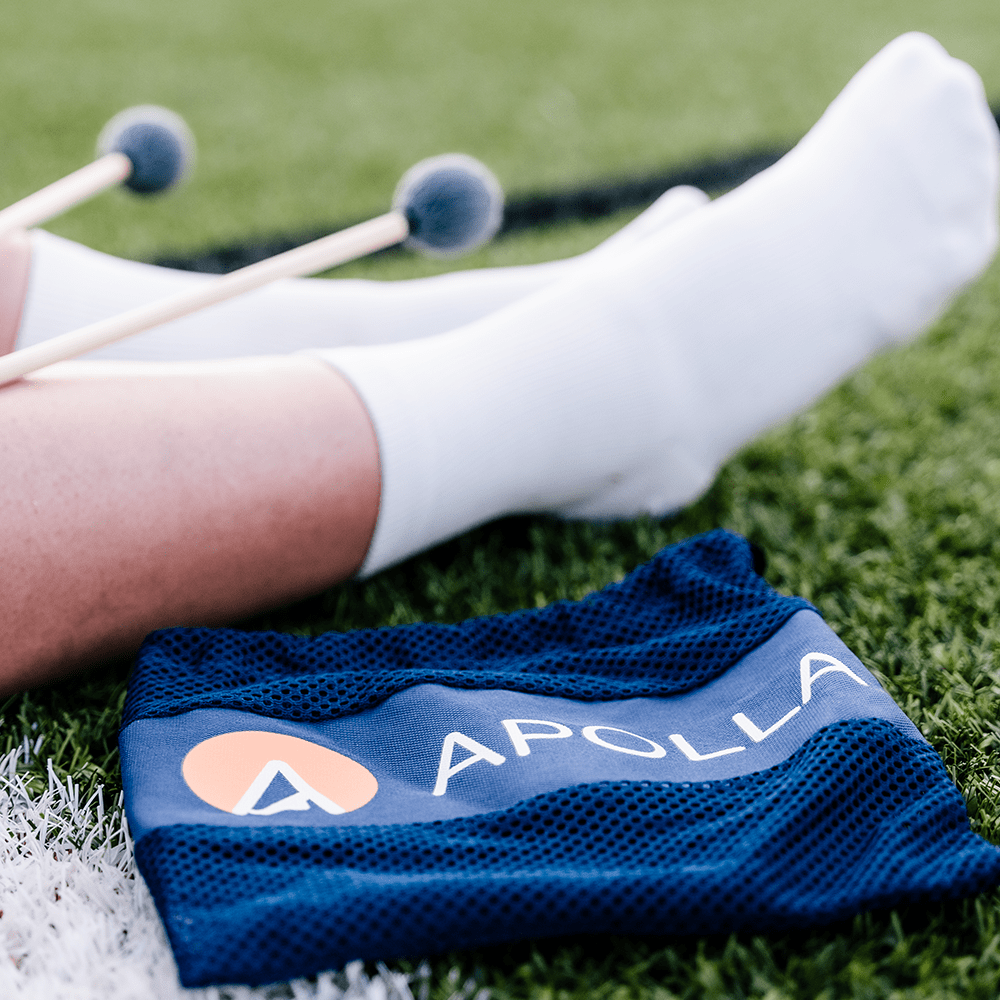Marching band wearing white compression socks next to mesh bag