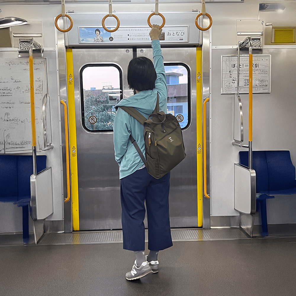 Gray crew socks for foot pain relief worn by woman riding a train