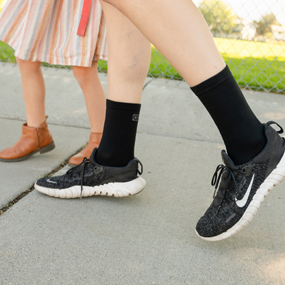 Mother wearing best compression socks for pregnancy while walking with daughter