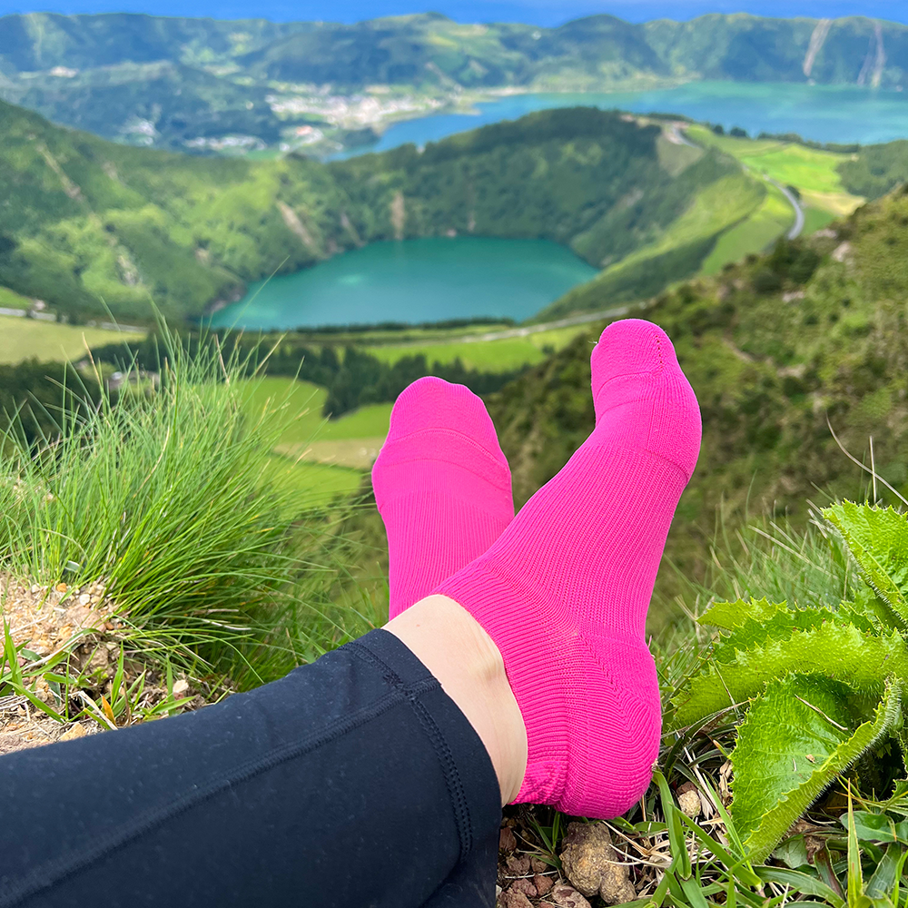 AMP fuchsia support socks on a mountain top