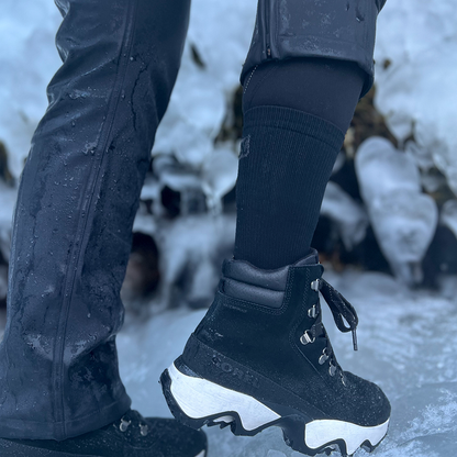 Black boot socks with compression worn by woman hiking