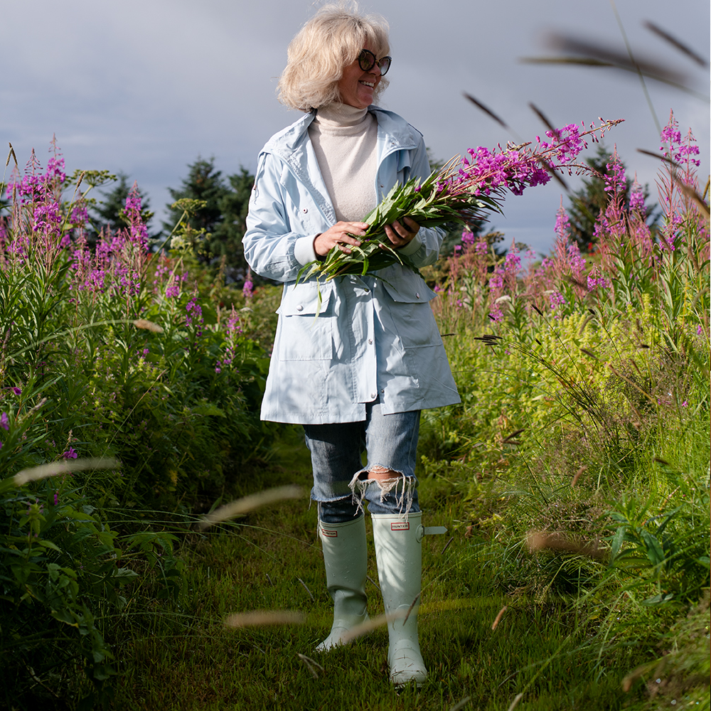 Apolla boot socks with compression worn by woman picking flowers 