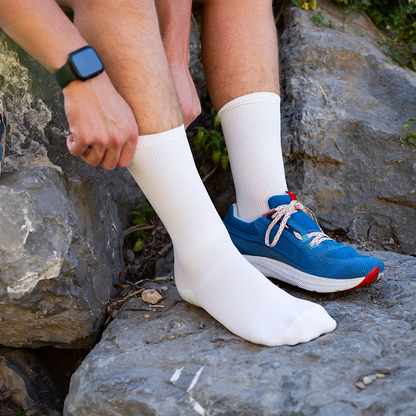 White mid calf compression socks for ankle support put on before hiking